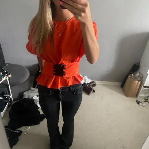 Topp - En jättefin orange topp med knytdetalj där fram som man även kan knyta där bak om man vill💕säljer då den inte kommer till användning längre 