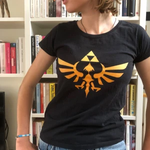 zelda t-shirt - säljer denna feta t-shirt med the legend of zelda-tryck! perfekt för vanligt bruk + spelträffar och mässor. sparsamt använd och inga slitningar på trycket. nypris 239 kr.