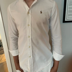 Polo Ralph Lauren skjorta - Tjena, säljer en vit polo skjorta i 10/10 skick och den är använd en enstaka gång. Nypris: 1699kr. Kontakta gärna om ni har frågor