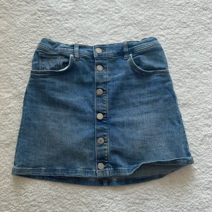 Gant Low Waits jeans kjol - gant låg midjas jeanskjol med knappar. Går att skjutsars i midjan. Storlek 158/164