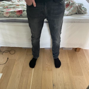 Nudie jeans - Säljer ett par gråa Nudie jeans med slitningar i storlek 28 28 men sitter som 28/30. Sitter lite stora på mig som är 170. Skick 9/10 pga dem har lappats men syns knappt. 