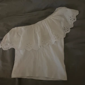 Vit topp - Säljer denna vita one shoulder toppen från zara. Super fint skick använd några få gånger. Tryck bara på köp nu!