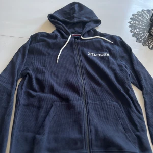 Tommy Hilfiger stickad zip  - Säljer denna fina tröjan som är helt oanvänd, den har kvar alla lappar. Säljer för den passar inte, de står den är i M men skulle kunna säga den är stor M eller Liten L. ÄR 180 och den passar inte för den är för stor. Ny pris är runt 800-900.