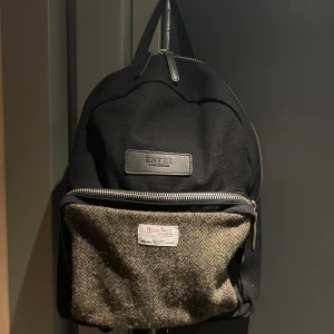 Harris tweed ryggsäck  - Normalstor ryggsäck, är osäker på liter antal men passar allas rygg. Bara använd ett par gånger så den är i bra skick. Datafack finns och rymligt ytterfack.