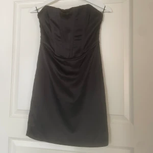 Svart satinklänning utan band  - Jag säljer min oanvända jättesnygga klänning köpt på Gina tricot. 