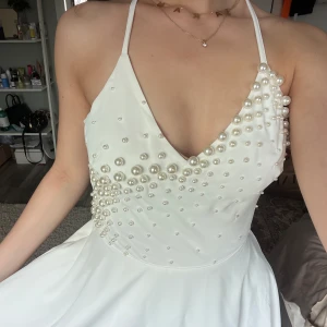  ✨vit klänning med handsydda pärlor - Säljer denna nya studentklänning som min mamma har handsytt  pärlor på.  Oerhört vacker och unik🥹 Ingen kommer ha en likadan klänning😍 blev tyvärr helt oanvänd. Passar s-xs