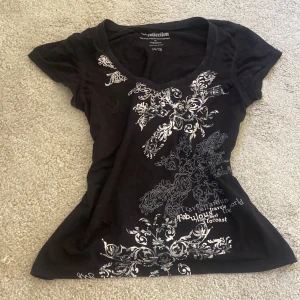 Tröja med tryck - Svart v-ringad t-shirt med tryck på. Kommer från Lindex och är i bra skick.