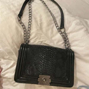 Svart axelbands väska  - Så fin väska, inspererad av dyrare märke (plick tar bort annonsen när jag skriver vilken väska den är kopia av :) men så stilren och fin väska! 💗 insidan är sliten då dragkedjan är trasig. dm för frågor o prisförslag