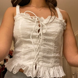 Hm topp - Säljer denna söta topp med snörning i storlek 38 för 50kr. Den är använd fåtal gånger och är från H&M. 