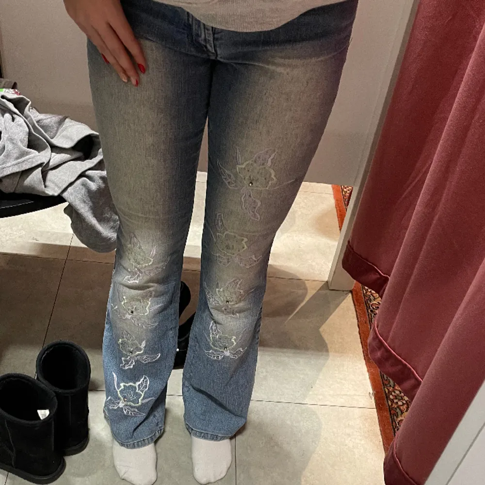 Säljer dessa lågmidjade jeans med blommor på benen och pärlor, de är i strl M men skulle säga att de passar S med💕 superfint skick förutom knappen som är lite lös och glappig. Jeans & Byxor.