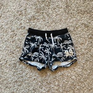 Shorts  - Svarta shorts med vita palmer på och 99 i silvrigt glitter på vänstra benet🖤🤍