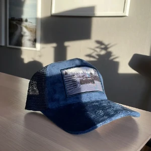 Velvet keps ”F1” - Trycket "F1" är fartfyllt och stilrent, med svartvitt hålls profilen ner och kepsen passar vem som helst. Både den motorsport-intresserade eller den som bara tycker att det är snyggt.   Material: Velvet Färg: Marinblå  OBS‼️ BEGRÄNSAT ANTAL✅