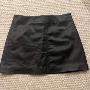 Fusk skin kjol från HM. Strl 44. Längd 40 cm. Färg svart.