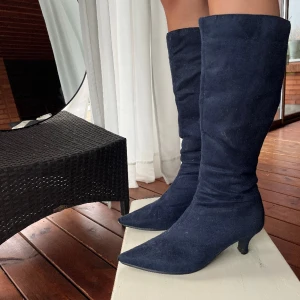 Klackar - Mörkblåa klackar, spetsiga med smal klack i mockaimitation. Fraktkostnad tillkommer. 