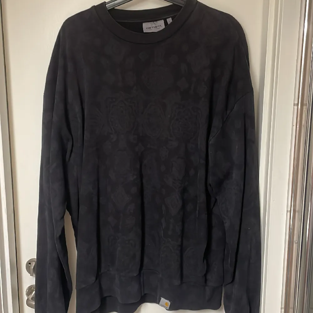 Snygg svart sweatshirt från carhartt med mönster på, mönstrerna syns inte så mycket. Använder aldirg längre, därför jag säljer.  Strl L, sitter lite baggy. Skick 9/10  Nypris runt 1000kr . Tröjor & Koftor.