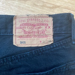 Svarta Levi’s 501 W32 L34 - Säljs dessa fina Levi’s 501 då de inte kommer till användning. Storlek W32 L34. 100% bomull ingen stretch. Sömmen har lossnat på ena kanten på lappen i bak men annars i bra skick. Passar mig som är 179 cm lång. Skriv för fler bilder eller vid frågor!