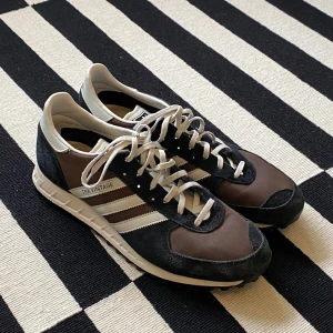 Adidas TRX sneakers  - Adidas Vintage TRX sneakers brun/svart/vit.  Använda ett par gånger, sulan är i gott skick. Se slitage på mockan på sista bilden.   Storlek 46 men passar 45. 29,5cm innersula.