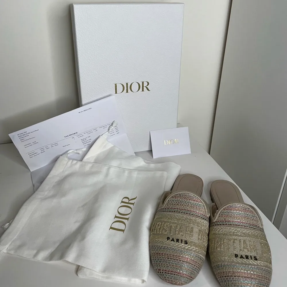 Ett par eleganta dior skor i en mångfärgad metallisk design. skorna kallas för mules. Skorna har en platt sula och är dekorerade med texten 'Christian Dior Paris' på ovansidan. kommer med kvitto (äkta).. Skor.