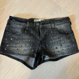  snygga vintage  jeansshorts från bershka  - Säljer dessa coola lågmidjade vintage shorts med stjärndetaljer både bak och fram De är i st xs men skulle kunna passa s De är svarta/gråa i färgen