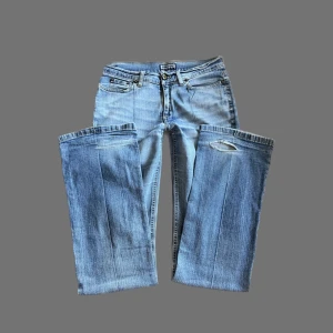 LÅGMIDJADE BOOTCUT Y2K JEANS - Jättefina lågmidjade bootcut jeans köpta på 2000-talet! 😍 finns ett hål vid benöppningen på baksidan. midjemått 37cm tvärsöver innerbenslängd: 85cm. P.S. GÅ IGENOM MITT KONTO NI KOMMER HITTA MÅNGA Y2K OCH VINTAGE PLAGG 