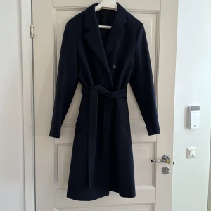 Fodrad marinblå kappa från Filippa K i storlek 42 - Fodrad 3/4 lång kappa från Filippa K i storlek 42, oanvänd. 