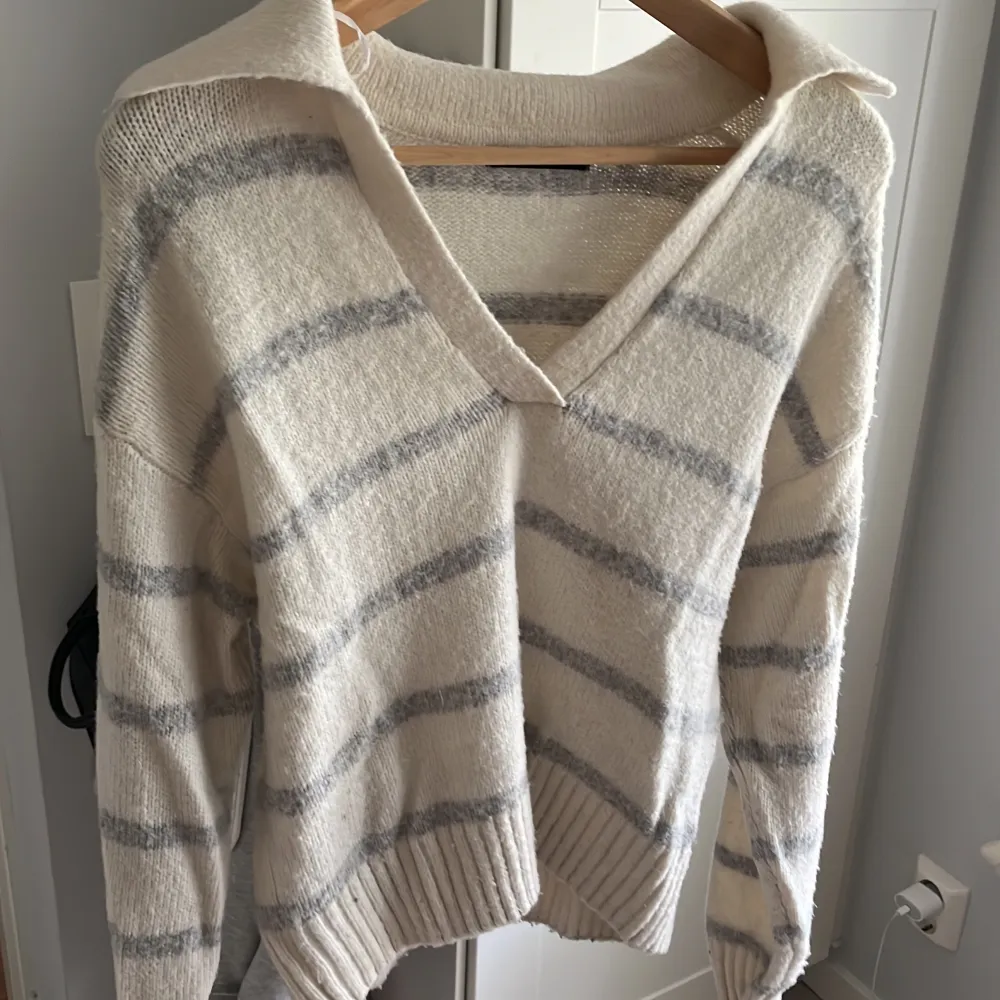 Sticka stödja med rönder från gina, har en v urringning med en liten krage där bak. Typ gul/beige med ljusgråa ränder💞xxs men sitter som en xs. Neuleet.