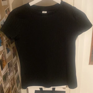 Svart ribbad t-shirt🩷 - Svart ribbad t-shirt. Väldigt bra skick, men den är använd. Den passar i många stilar beroende på hur man stylar den. Perfekt basplagg nu till hösten. Skulle säga att den är perfekt till hösten eftersom den är ganska varm. Fråga om ni undrar något💗