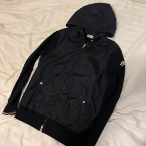 Moncler cardigan - Säljer min Moncler cardigan! Den är 9/10 i skick och det finns inga defekter då den använts i ett gott skick. Den är i storlek L men passar även M och S eftersom den är liten i storleken. Det finns självklart kvitto och orderbekräftelse på jackan!
