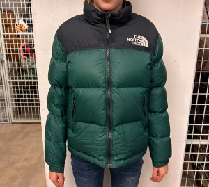 The north face puffer - Grön/svart puffer. Jr storlek L, motsvarar Dam XS.   Personen på bilden är 165cm