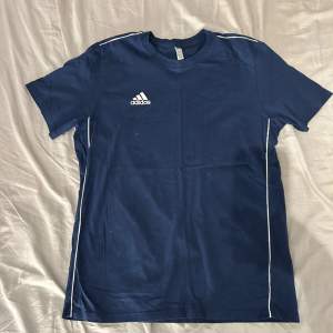 Mörkblå Adidas t-shirt som har vita detaljer, knappt använd och bra skick! 💙