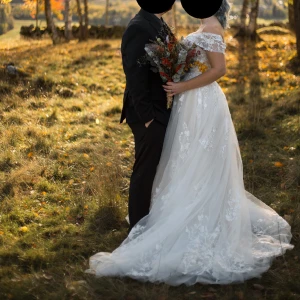 Brudklänning - Brudklänning använd 1 gång & har kemtvättats efter.  Stor kjol, långt släp & är lätt glittrig upptill.  Spets+tyll = vit  Undertyg = champagne   Byst 98cm Midja 78cm Längd från midja 100cm Jag är 173cm lång  Passar större strl än mig pga snörning i ryggen