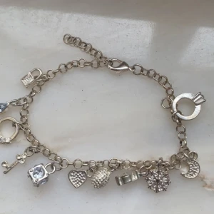 Silvrigt armband med många berlocker - Lite rostigt men fortfarande fint