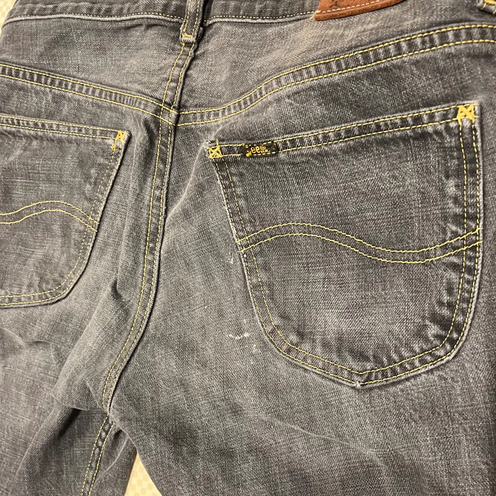 Grå jeans från Lee, några slitningar längst ner på benen. Några vita fläckar vid höger bakficka. W:32 L:34.. Jeans & Byxor.