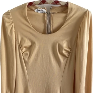 Vintageklänning - Italiensk vintagekklänning i 100% polyester, dålig på att datera men kan det vara 60-70 tal? Dropwaist och vackert veckat tyg som gör att den sitter väldigt fint, långa puffiga ärmar. Ett spänne saknas i nacken men finns ett extra som skickas med.