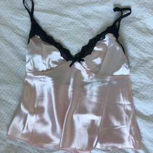 Rosa spetstopp - Superfin rosa topp i silke med svart spets, sitter perfekt på en storlek s💗