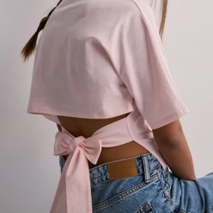 Open back tie tee  - Säljer denna trendiga slutsålda toppen från Nelly, endast använd en gång💛