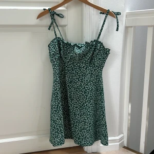 Blommig miniklänning - Grön miniklänning med vita små blommor. 