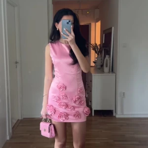 Rosa klänning med blommor - Finaste klänningen någonsin med blomdetaljer. Från bella barnett. oanvänad med prislapp. St s, minsta storleken så motsvarar xs. Köptes för 800 kr, säljer för 600.