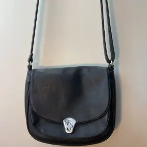 Vintage handväska köpt secondhand. Den har ett fack på framsidan, två fack inuti samt ett med dragkedja och ett fack med dragkedja på baksidan. Väldigt rymlig och smidig. Den är väl använd och lite sliten på vissa ställen men inga tydliga defekter. 