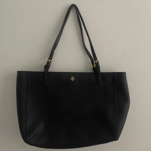 Tory burch - En snygg svart väska från tory burch! Väskan har många fack och bra förvaring! Den är fräsch och i mycket bra skick, förutom att ena handtaget är lite slitet. 💕  Pris kan alltid diskuteras!