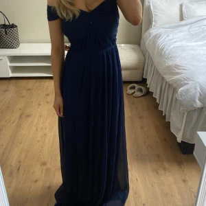 Balklänning  - Säljer min balklänning från förra året! Den är köpt på Nelly och har jättefin mörkblå färg, man kan ta axelbanden på två olika sätt. Klänningen är i storlek 36/S och är lite för lång på mig som är 165 cm även med klackar.