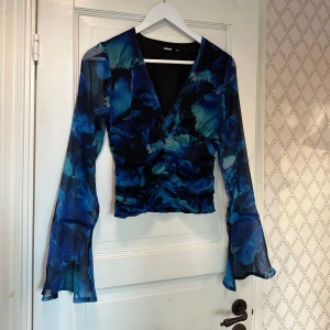 Blus - Flerfärgad blus med utsvängda armar i mersh. Storlek XS men passar även S. Aldrig använd.