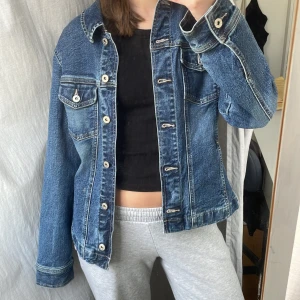 Jeansjacka  - Jeansjacka i en mörkare tvätt, och silvriga knappar. Från L.O.G.G. H&M storlek 38. Sitter lite oversized på mig som har storlek 34. I bra skick! 