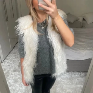 Vit pälsväst - Säljer denna vita pälsväst då den inte kommer till användning. Det står i den att den är ifrån 11-12 år, men skulle säga att den är som en xs ungefär💓 bild 1-3 är lånad!! Lite sliten med nån minifläck gömd här och där i pälsen!