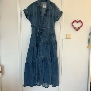 Zara jeans klänning - En skit fin jeans klänning från zara i nyskick. Aldrig använd utan lappen lossnade så jag fick inte möjligheten att lämna tillbaka den. Jätte snygg inför sommaren och är öppen för prisförslag. Köpte klänningen för 1000kr❤️