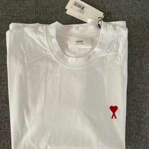 Säljer min Ami Paris t-shirt  - Helt ny med tags kvar, väldigt fin och otroligt skön Ami Paris t-shirt. Säljer då den inte satt som jag önskade den skulle, storlek S men passar M ocå
