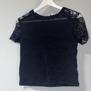 Cropped t-shirt  - Cropped t-shirt som känns väldigt lätt och sval. Axlarna är synliga då de är gjorda av spets 