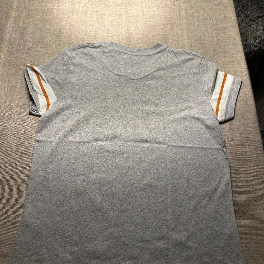 Gant T-shirt Grå med orange vita ränder på armarna. . T-shirts.