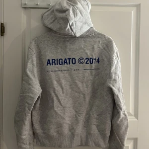 Axel Arigato Hoodie - Säljer nu min grå hoodie med blått tryck på ryggen. (London hoodie). Köpt för 1600 och säljs inte längre. Storlek S. Den är sparsamt använd. Hör av er om ni har frågor! 