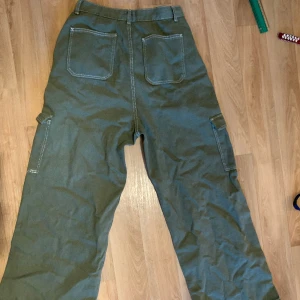 Gröna cargos - Han färg på framsidan men knappt använda. Står storlek 38 men måttet på midjan är 35cm    Benöppning är 28cm